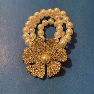 Beautiful three pearl band bracelet with a breath taking flower; softly worn!